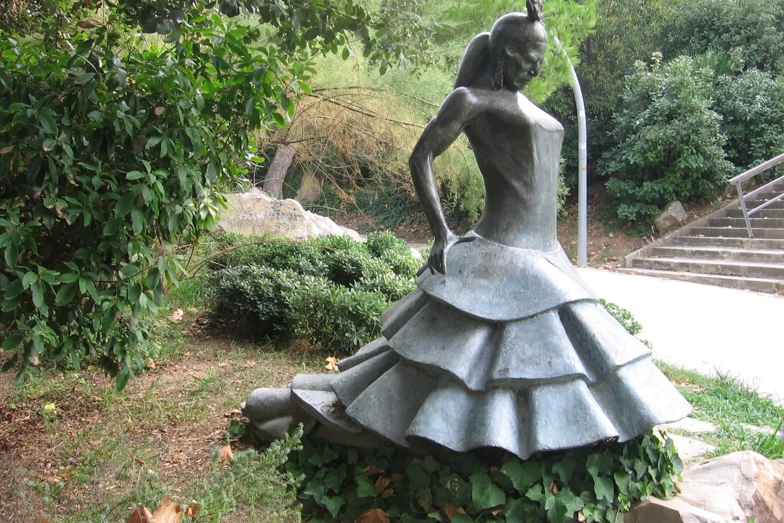 Eine Bronzestatue einer Flamenco-Tänzerin in einem Rüschenkleid, in einem Garten auf dem Montjuïc, die Carmen Amaya gewidmet ist